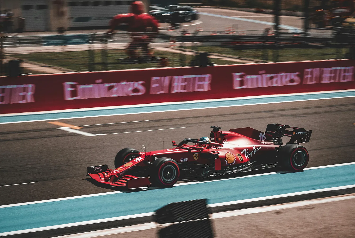 A red Ferrari racing car speeds around a track, showcasing its sleek design and powerful performance.