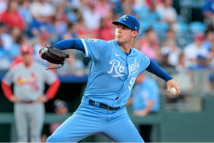 A baseball player in a blue uniform is in the act of throwing a ball on the field.