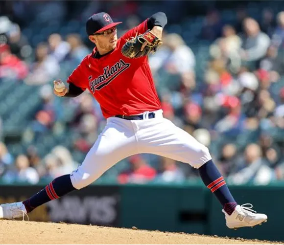 A baseball player in a red jersey is in the act of throwing a ball on the field.