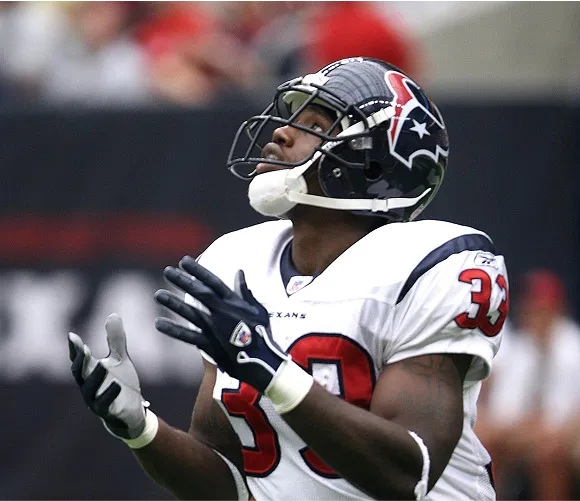 A football player in a helmet, poised for action on the field, showcasing athleticism and determination.