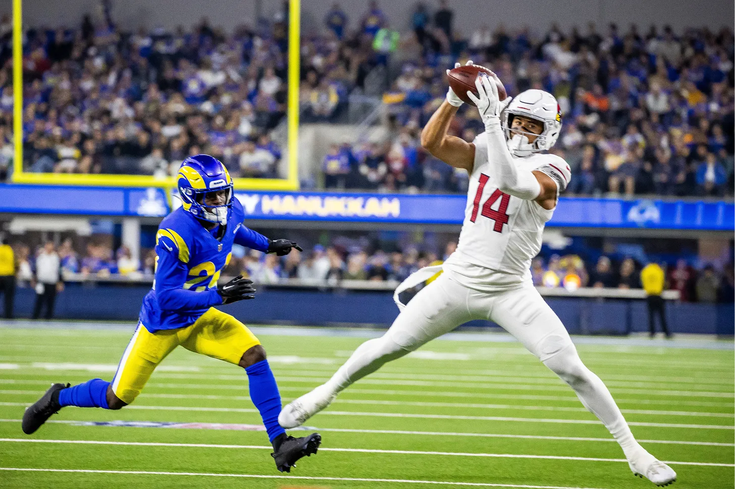 A football player leaps to catch a ball in mid-air, showcasing athleticism and precision on the field.